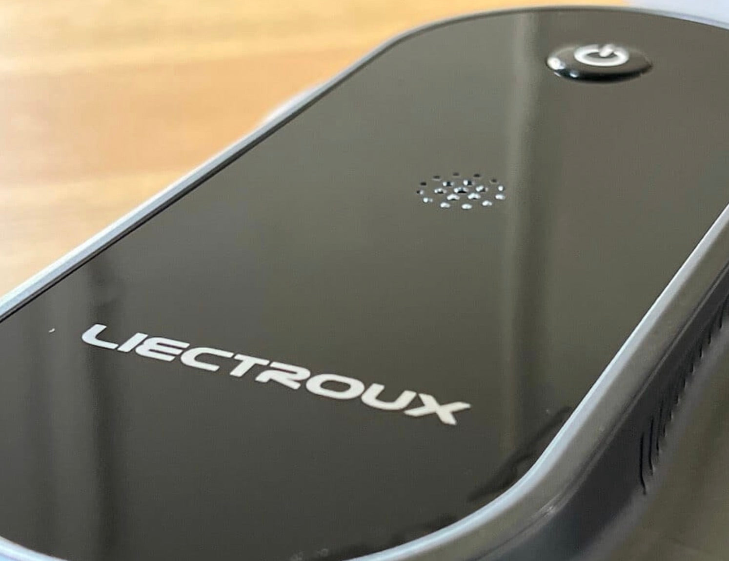 Detaljbild på fönsterputsrobot YW810 med Liectroux-logotyp och strömknapp, stilren design för automatisk fönsterputsning